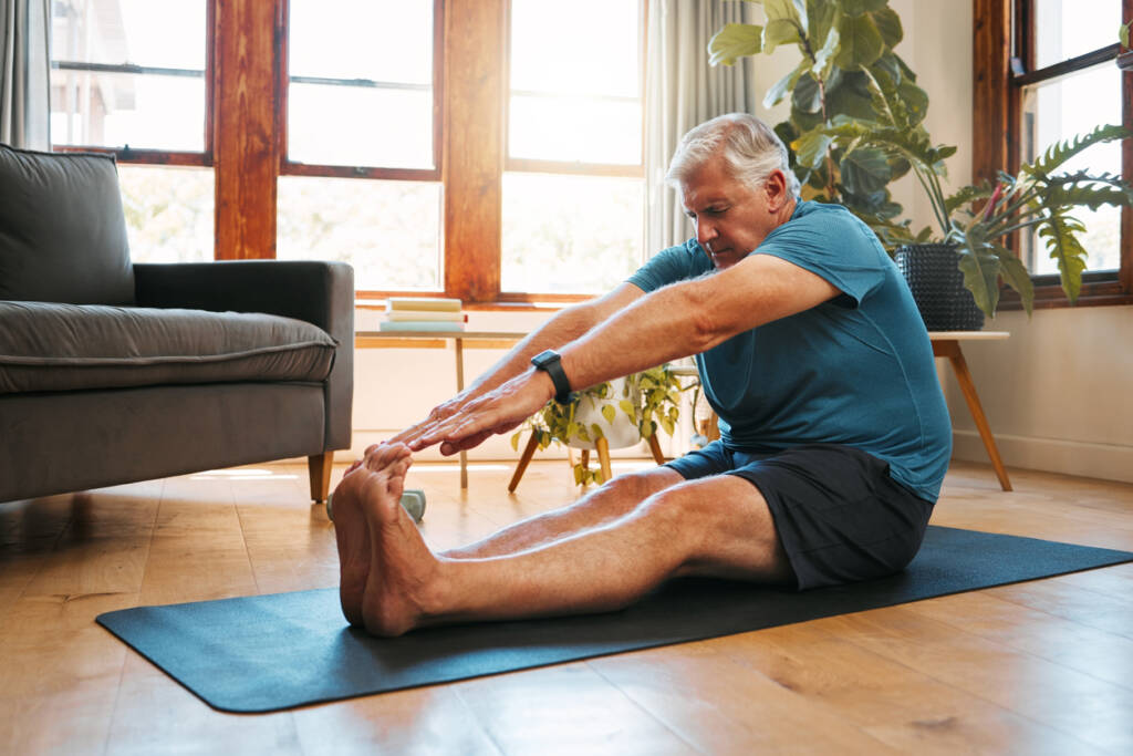 A man sitting on the floor doing yoga.