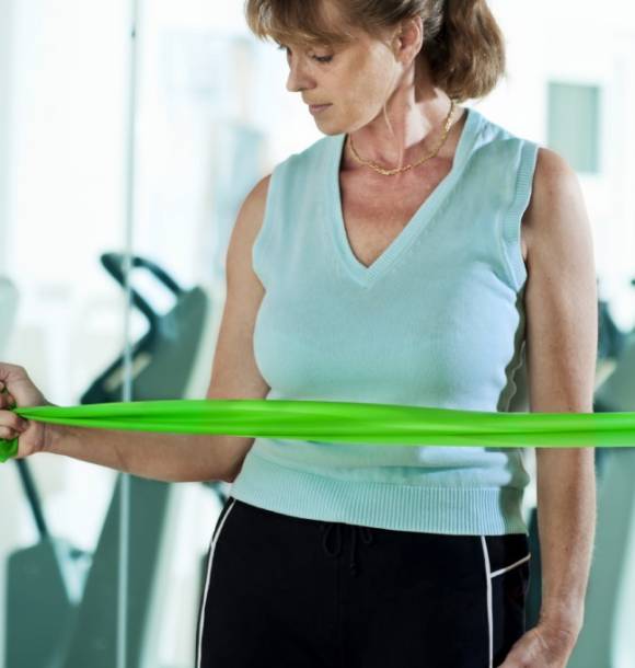 A woman holding onto a green hula hoop